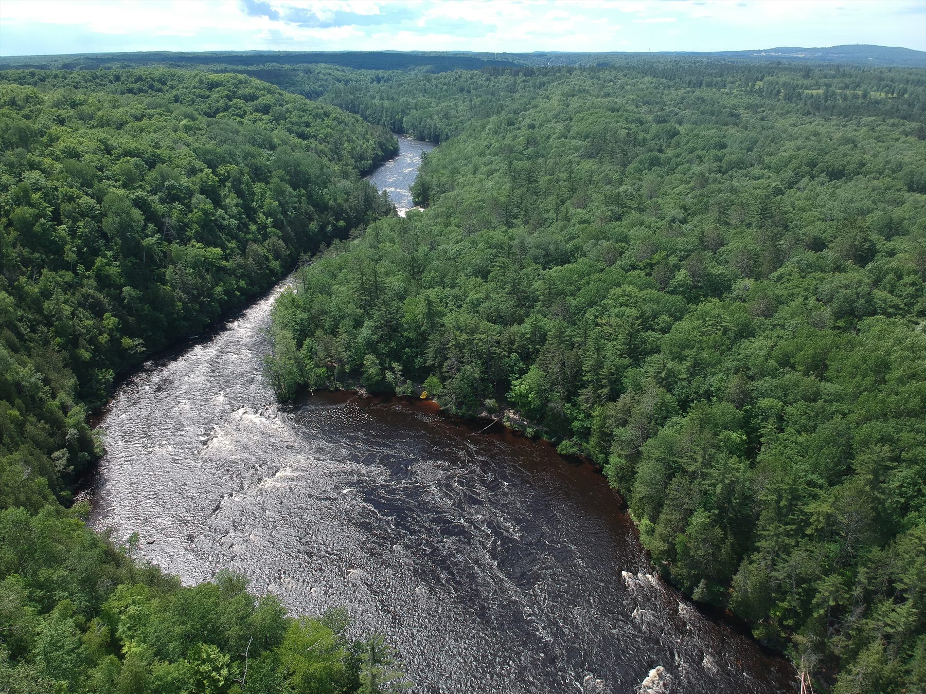 Aerial view of a rocky river corridor winding through forest