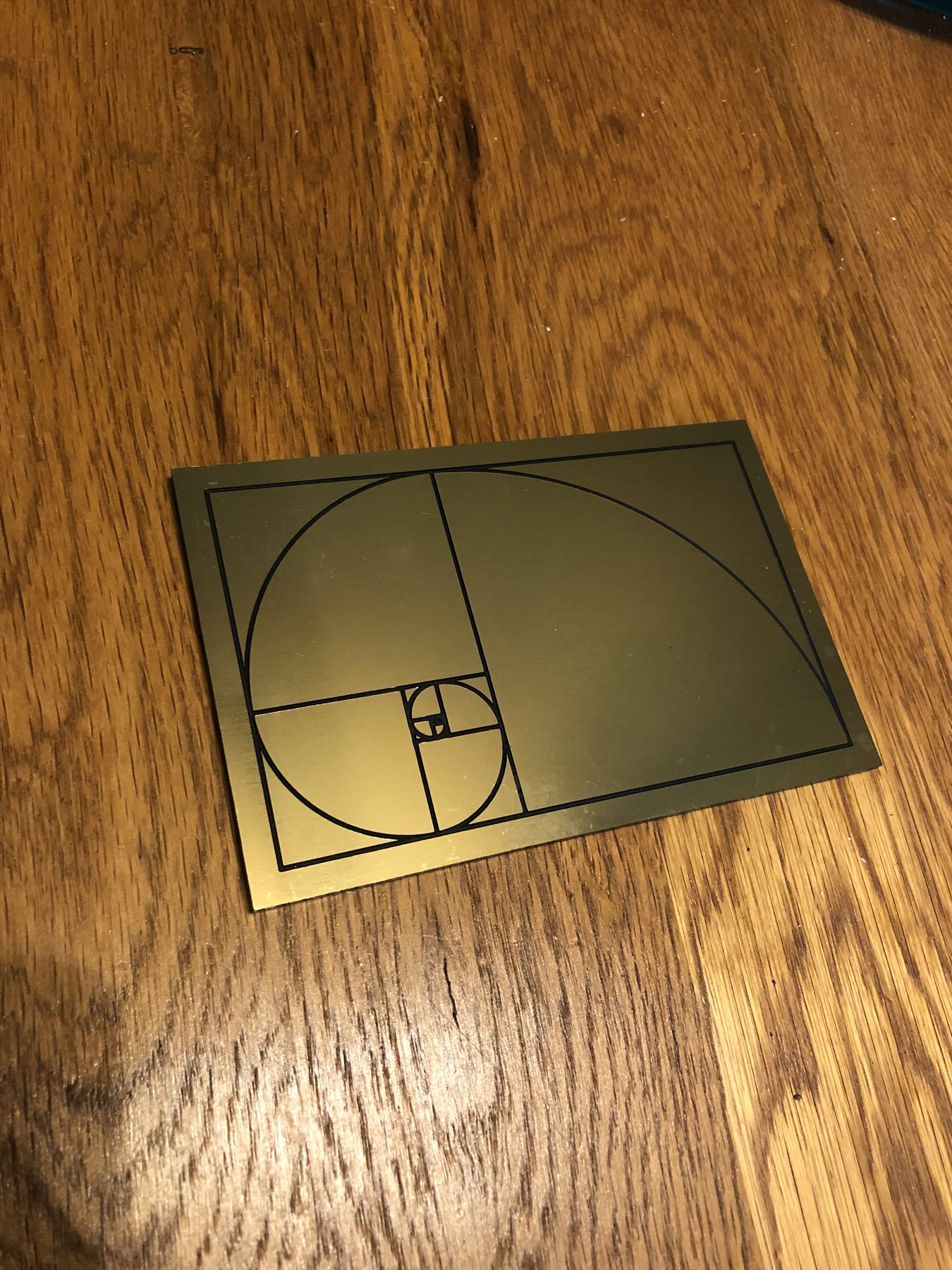 Small brass-toned golden-ratio rectangle and spiral inlay