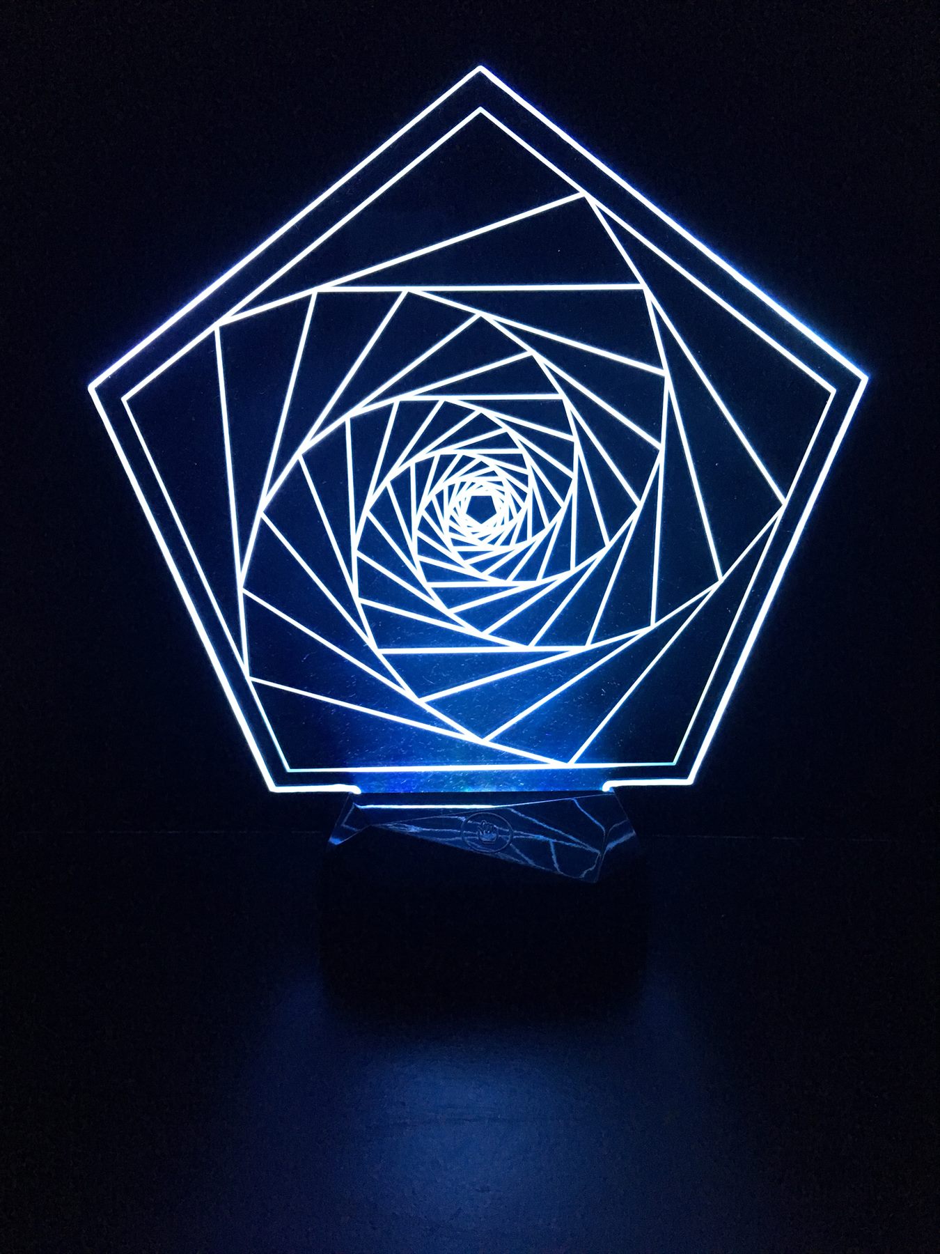 Blue illuminated acrylic panel engraved with a recursive spiral
