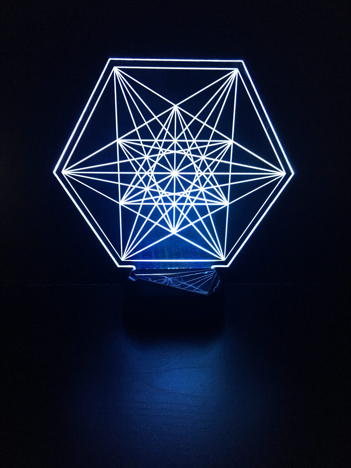 Blue edge-lit acrylic panel engraved with nested vector geometry