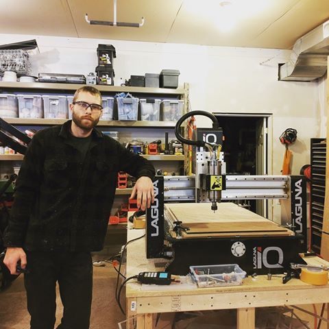 Ryan Nagy standing beside a CNC router in the fabrication studio