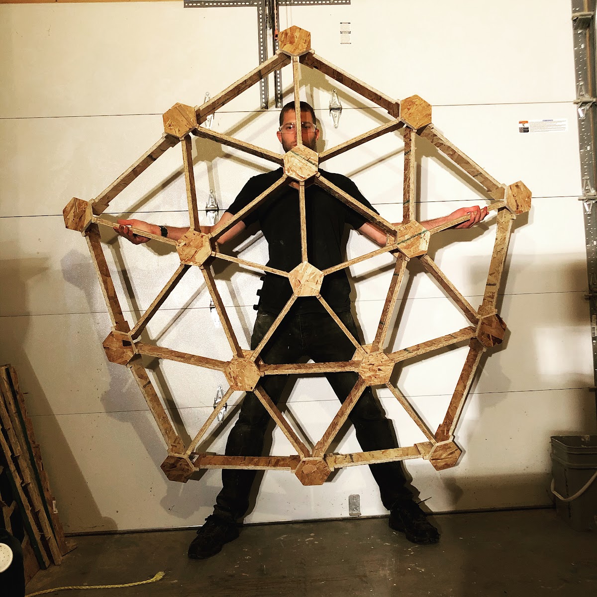 Ryan Nagy beside a geodesic shell structure